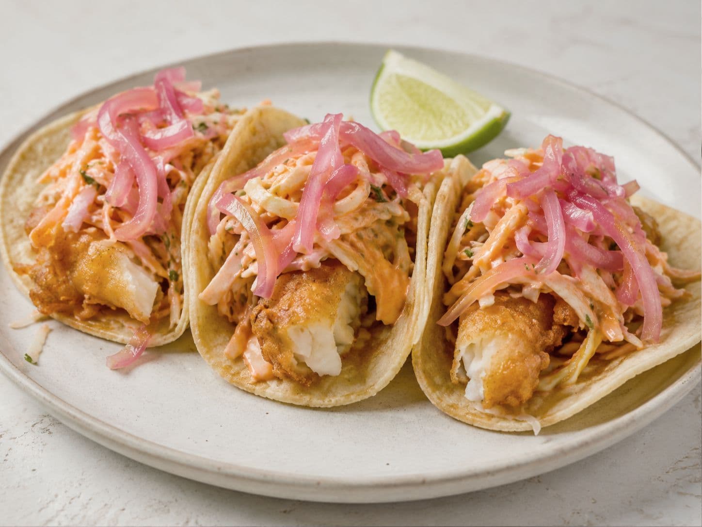 Crispy Baja Fish Tacos with Spicy Sriracha Slaw & Pickled Red Onion
